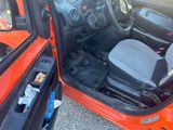 a red car with its door open and a black seat in it