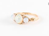 une bague en or jaune sertie d'un oplite et de trois diamants