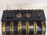 a black and gold machine with five different clocks on it