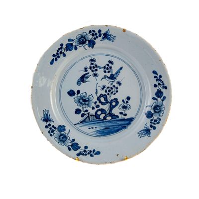 une assiette bleue et blanche ornée d'un oiseau et de fleurs