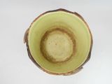 a green cup that is sitting on a white table