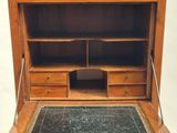 an old wooden desk with a marble top and drawers