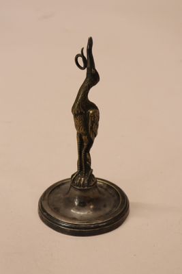 statue en bronze représentant un oiseau sur un socle, sur fond blanc