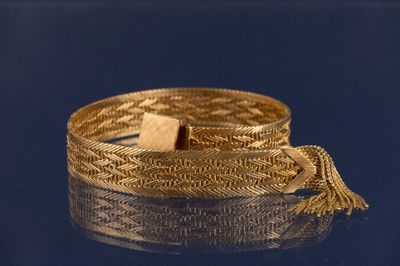un bracelet en or orné d'un bloc de bois