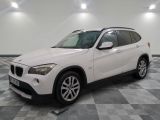 la bmw x1 est garée dans une grande pièce au sol en damier