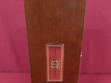 an old wooden box with a picture on it on a pink background