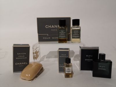 plusieurs flacons de parfum et un savon posés sur une surface blanche