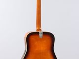 an acoustic guitar hanging on a wall with a white background