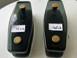 deux vases noirs posés sur une table blanche, sur lesquels sont apposées des étiquettes