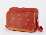 a red bag with a pattern on it sitting on a white surface