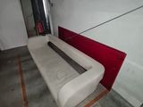 a white couch sitting in a room with a red wall