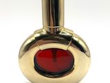 an image of a red glass perfume bottle on a white surface