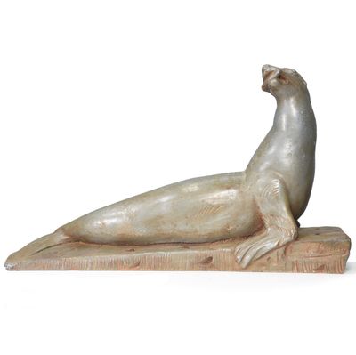 statue of a seal on a wooden base on a white background