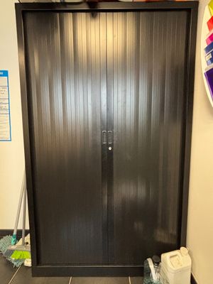 une porte en métal noir dans un coin d'une pièce