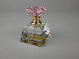 a small glass perfume bottle with a pink diamond on it