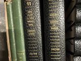 three books are stacked on a shelf in a library