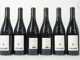 six bouteilles de vin sont alignées sur une table