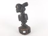 statue of a man holding a telescope on top of a piece of wood