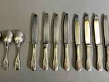 a lot of silver spoons and knives on a table