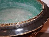 a green bowl sitting on top of a black table