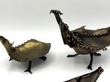 trois morceaux de métal posés sur une surface blanche