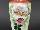 a vase with a painting on it sitting on a table