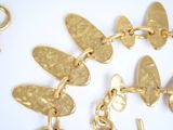 a gold bracelet that has a butterfly charm on it