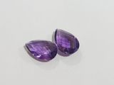 a pair of purple amethtites on a white surface