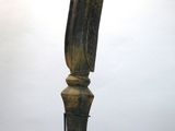 statue d'un oiseau posée sur un socle, sur fond blanc