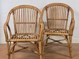 pair of rattan chairs with arms and backrests in natural wood