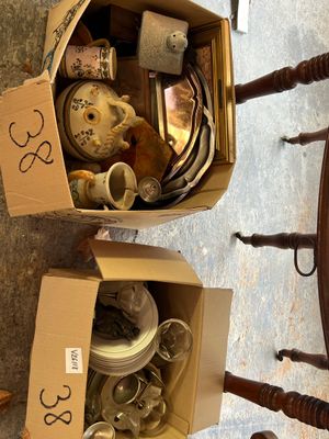 deux cartons remplis d'objets, posés par terre