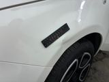 a close up of a white car with a sticker on it