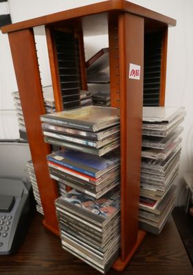 une pile de CD posée sur une table à côté d'un téléphone