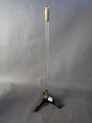 un gros plan d'un trépied métallique surmonté d'un tube en verre