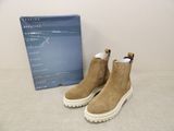 the shoes are tan sued with white soles and a box on the table