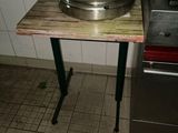 un fût en acier inoxydable posé sur une table en bois à côté d'un poêle