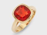 gros plan d'une bague en or avec une pierre rouge