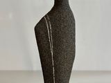 a black mannequin on a white table with a white background