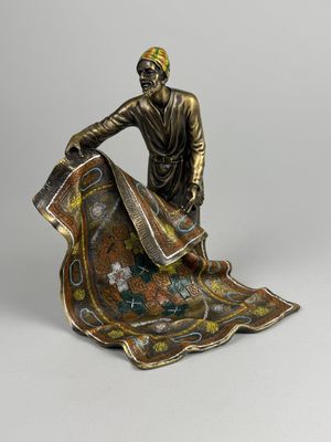 a statue of a man sitting on top of a blanket