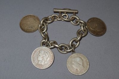 un bracelet en argent orné de pièces, posé sur une table