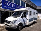une camionnette blanche garée devant un hôtel