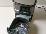 a black and silver coffee maker sitting on a white table