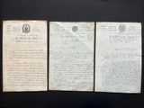 three old papers are on display in a glass case