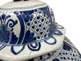 a large blue and white vase with a cat on top of it