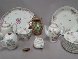 many plates, cups, and teapots on the table