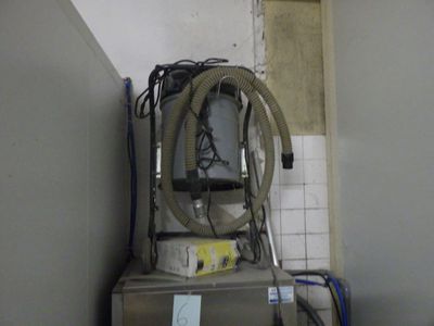 une machine à laver surmontée d'un tuyau