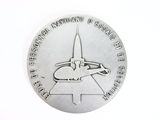 an image of a silver medal with a space shuttle on it