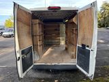 the back of a white van with its door open in a parking lot