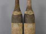 two bottles of wine sitting on top of a table next to each other