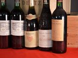 several bottles of wine are lined up on a red table cloth